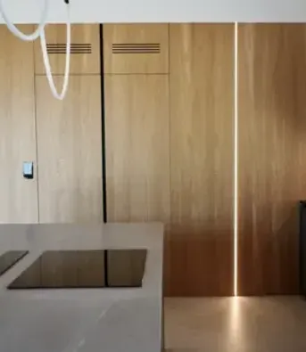 zdjęcie przedstawia zabudowę ścienną, gdzie fornir na ścianie przechodzi w fronty meblowe