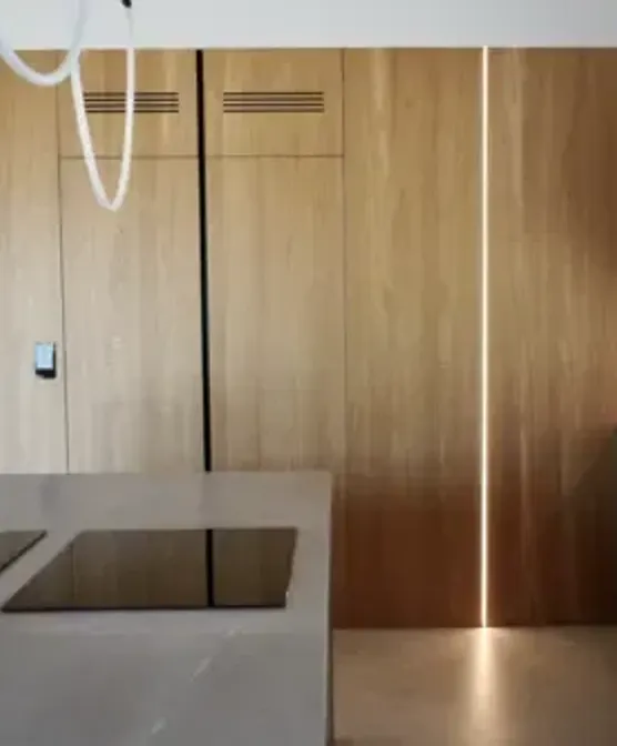 zdjęcie przedstawia zabudowę ścienną, gdzie fornir na ścianie przechodzi w fronty meblowe